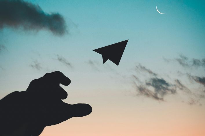 Silhouette Photo of Man Throw Paper Plane